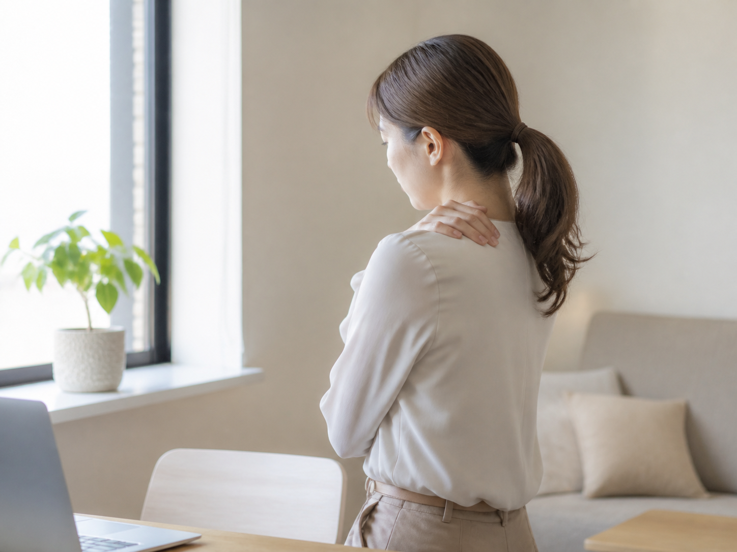 首や肩に手を当てる女性